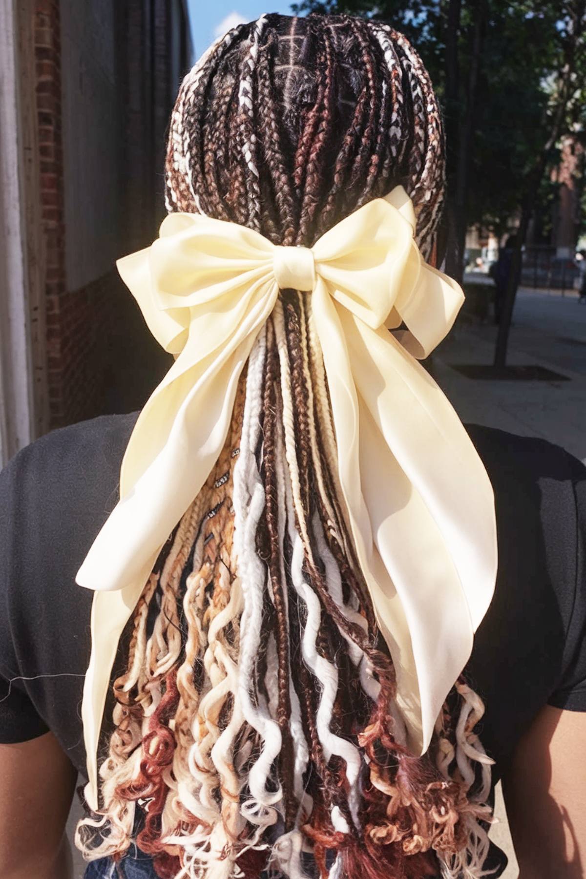 Square braids with French curls and a large satin bow