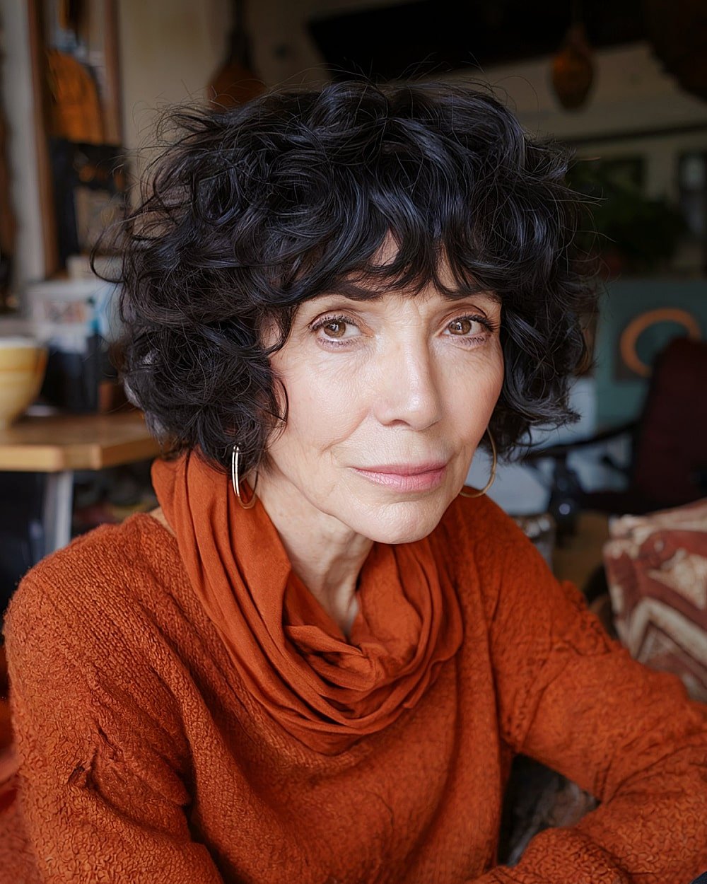 Curly French bob with choppy bangs for women over 60 with natural volume and texture