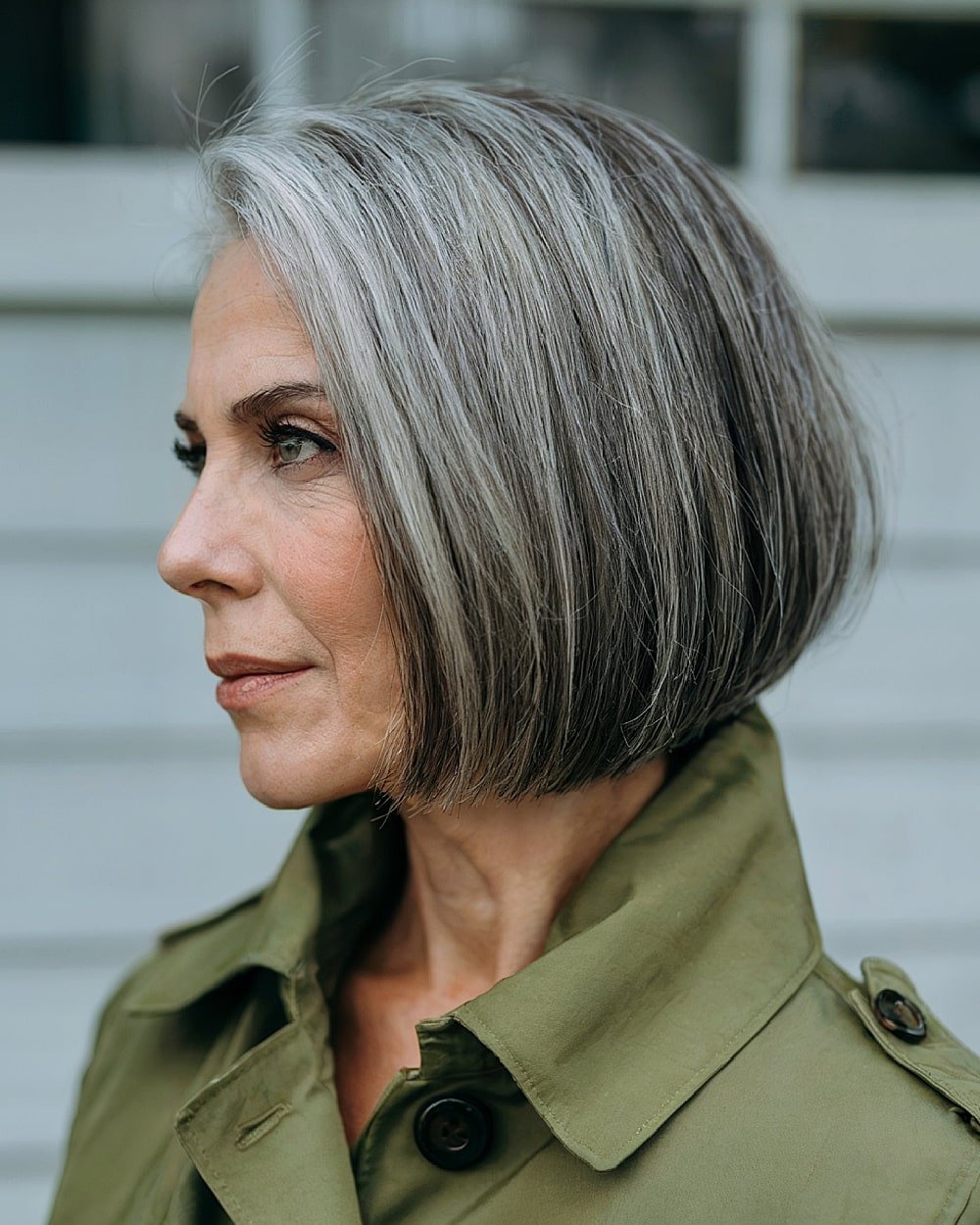 Curved blunt bob for women over 60 with sleek gray hair and soft inward bend