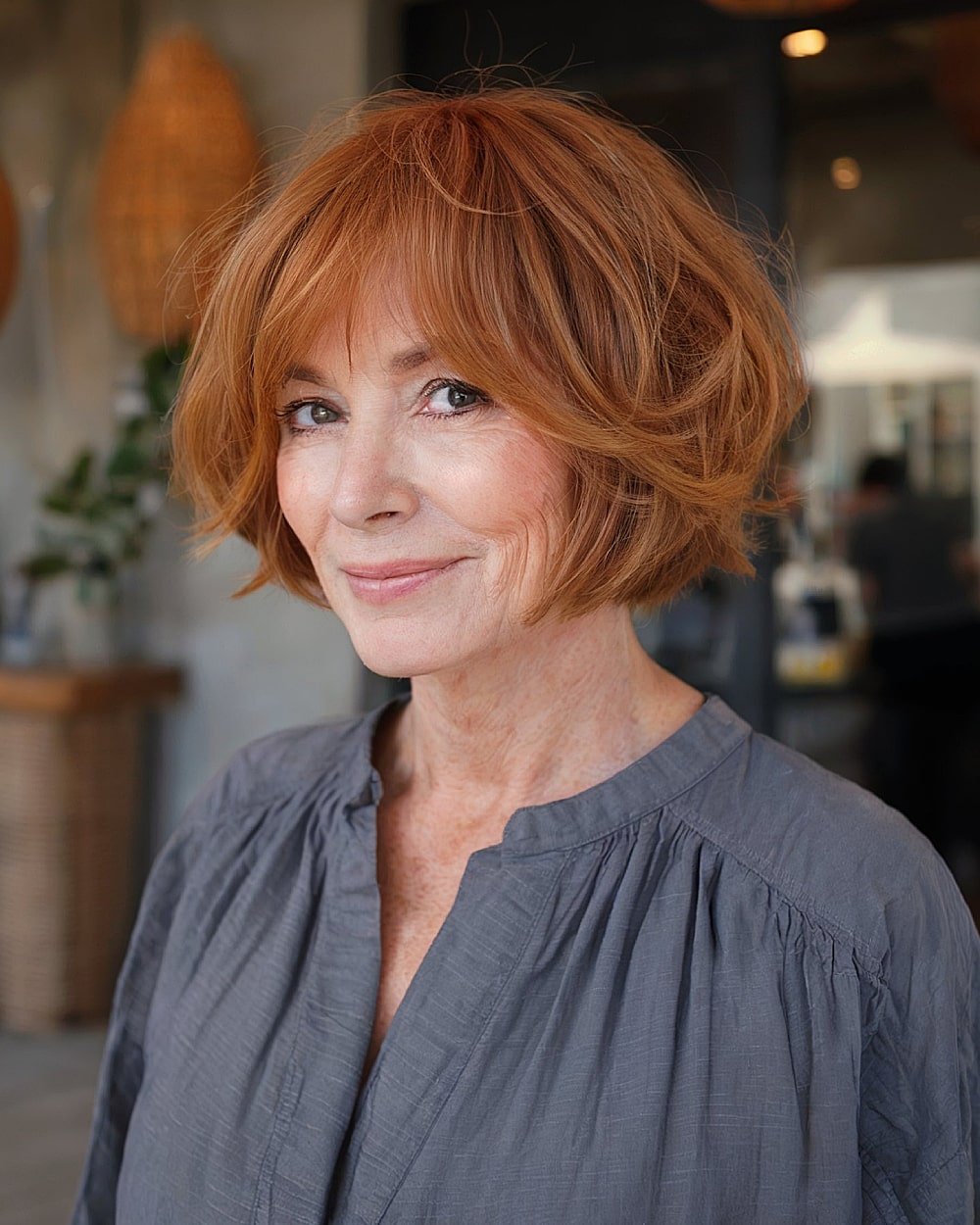 Layered bob hairstyle for women over 60 with choppy ends and soft copper waves