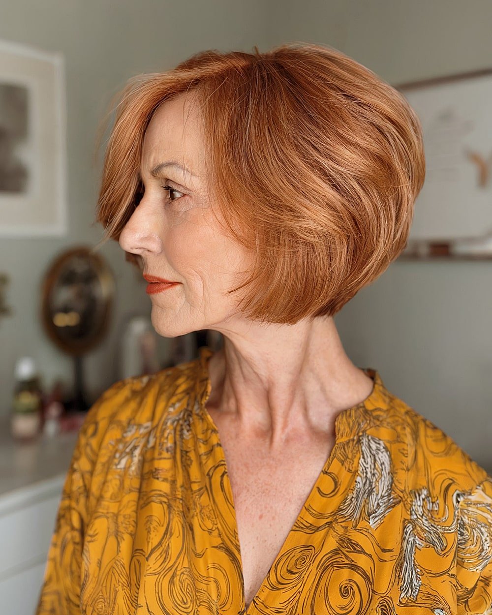 Layered tapered bob for older women with copper red hair and face-framing volume