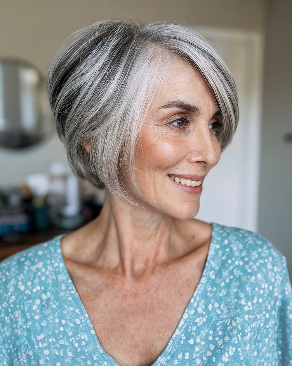 Side-swept salt-and-pepper pixie bob with soft graduation for women over 60