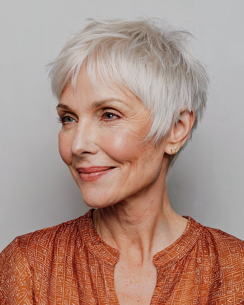 Feathered choppy pixie with side-swept texture for women over 60 with fine white hair