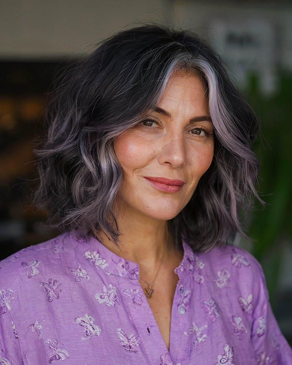 Wavy lob with peekaboo silver foil highlights on dark hair for dimensional grey blending