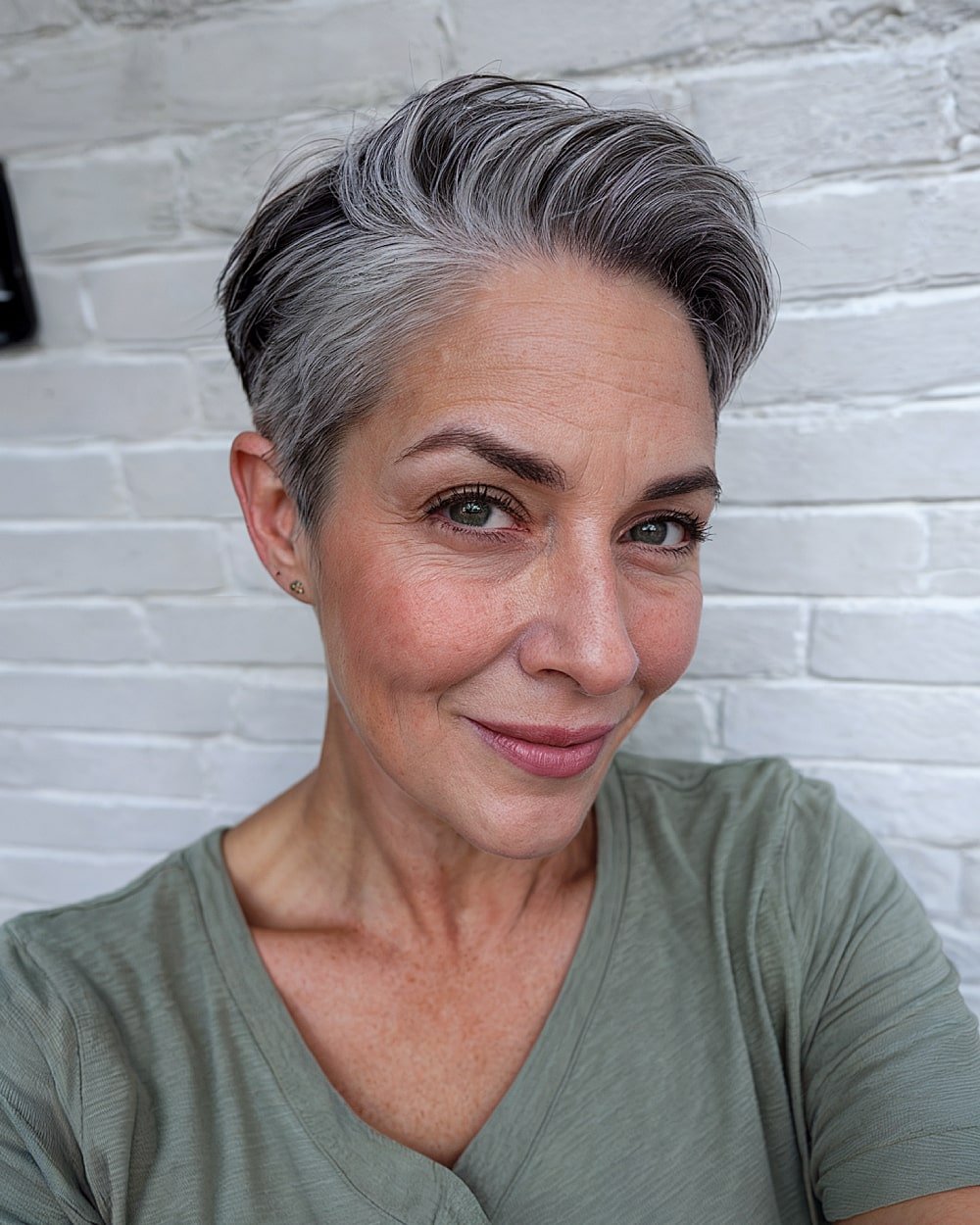 Salt-and-pepper tapered pixie cut on dark hair with blended grey and textured volume