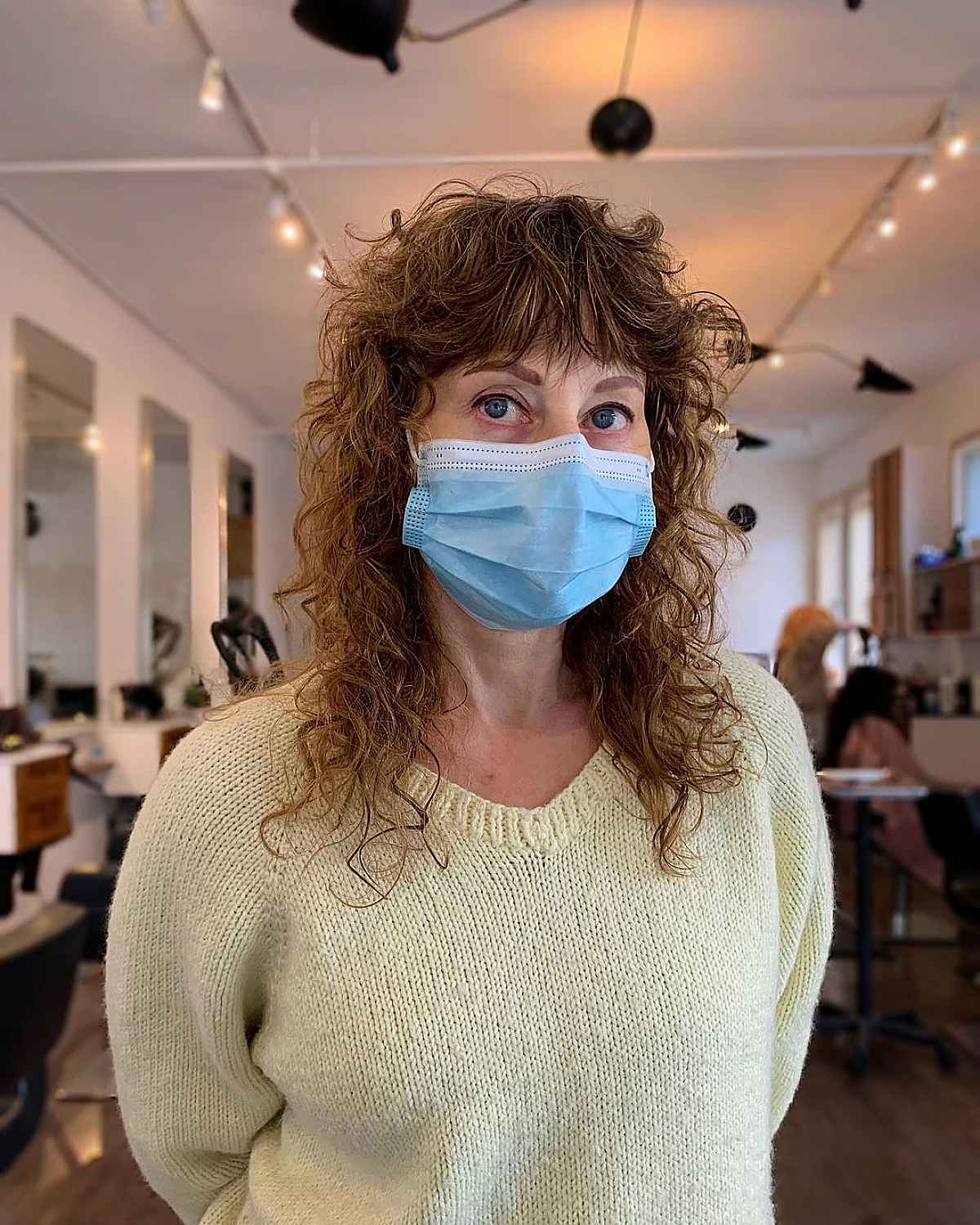 A medium curly hairstyle with rash layers for 60 -year -old women