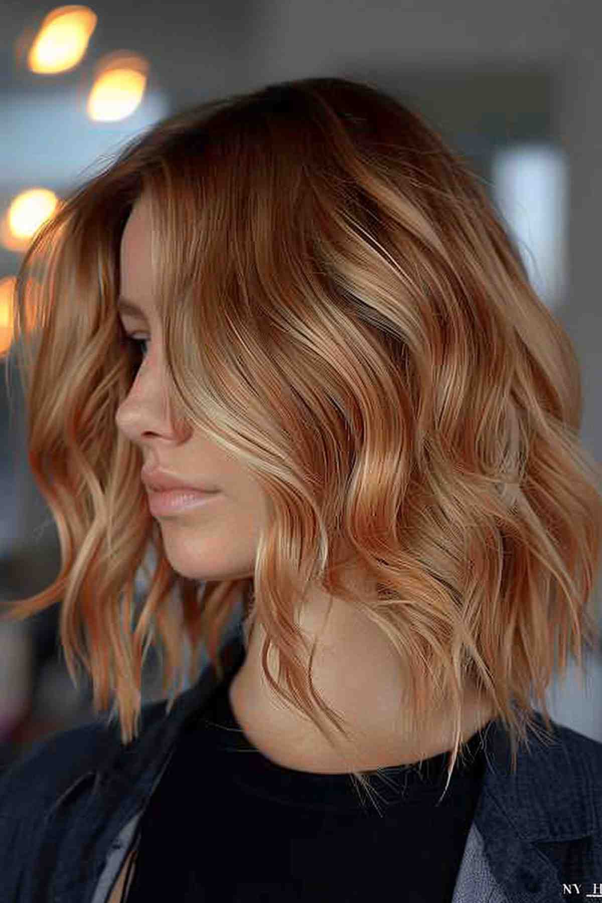 Strawberry blonde hair with medium length with warm caramel waves