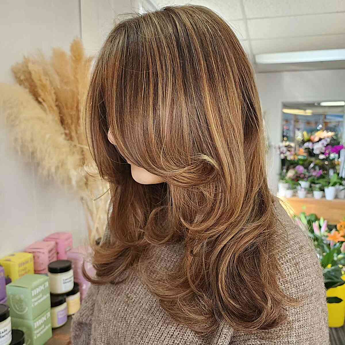 Warm caramel highlights on dark hair medium length
