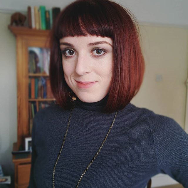Short red bob hair cut with sharp bangs