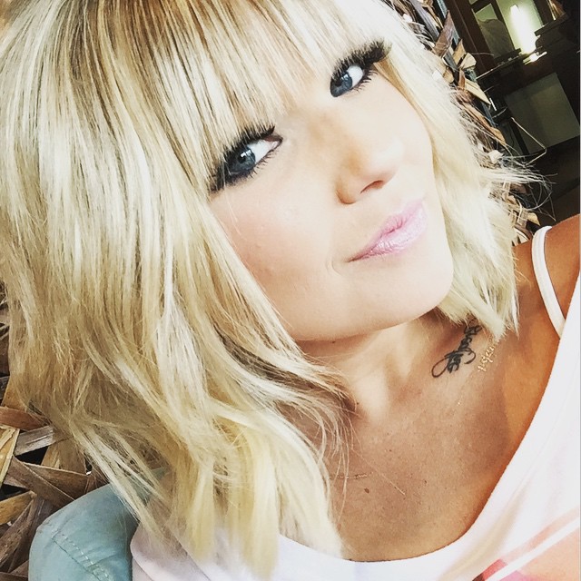 A soft, wavy hairstyle with straight bangs