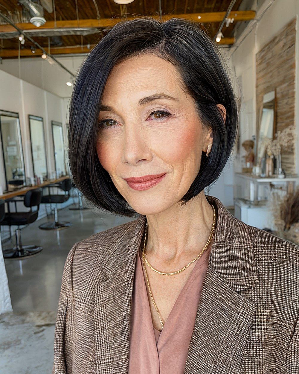 Polished stacked inverted bob with deep side part for women over 60 with black straight hair