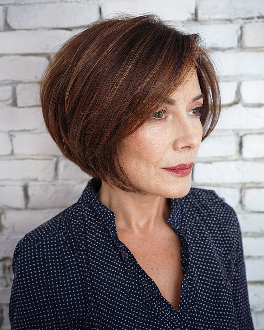 Asymmetrical stacked inverted bob with side part for women over 60 with chestnut brown hair