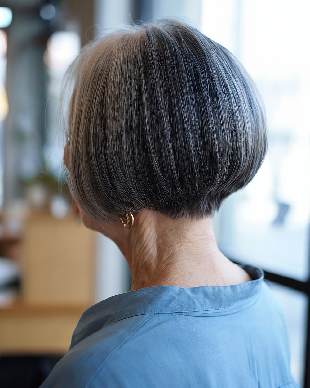 Stacked inverted bob with undercut detail for women over 60 with fine straight gray hair