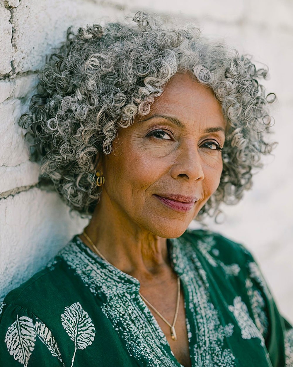 Curly stacked inverted bob with natural texture for women over 60 with gray coily hair