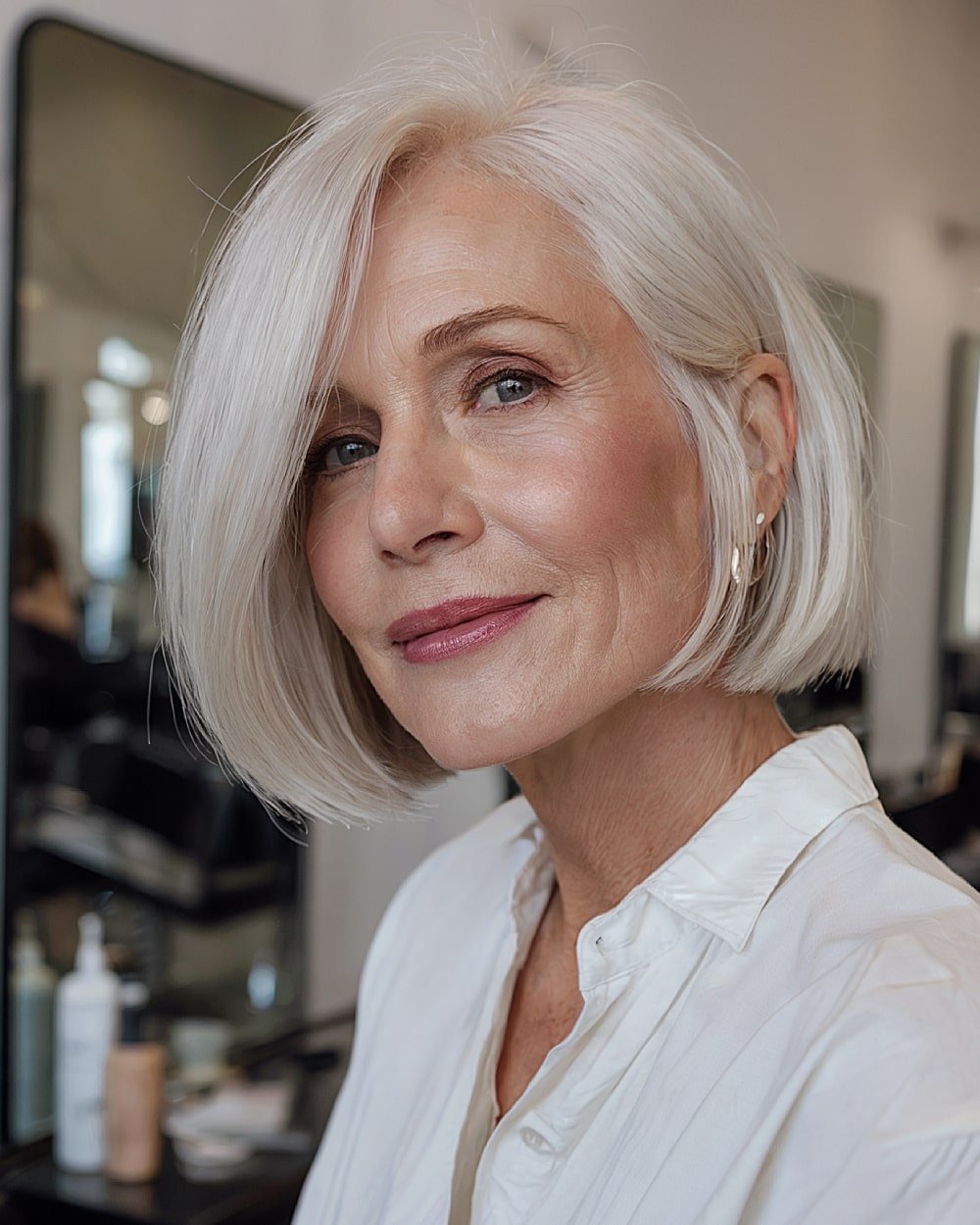 Sleek chic bob with side part and icy platinum color for mature women