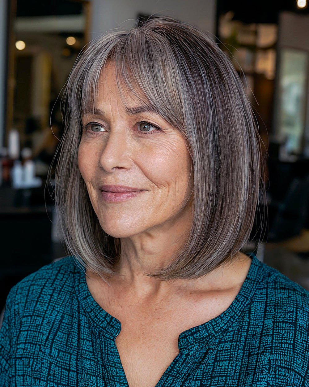Straight silver lob with curtain bangs and thin blended layers for older women