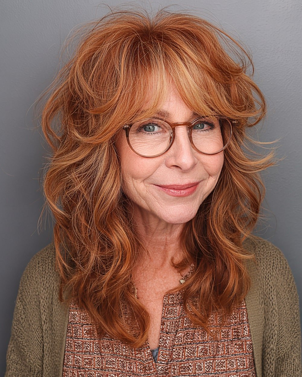 Medium, voluminous red hair with choppy layers and soft curtain bangs for older women with thick hair