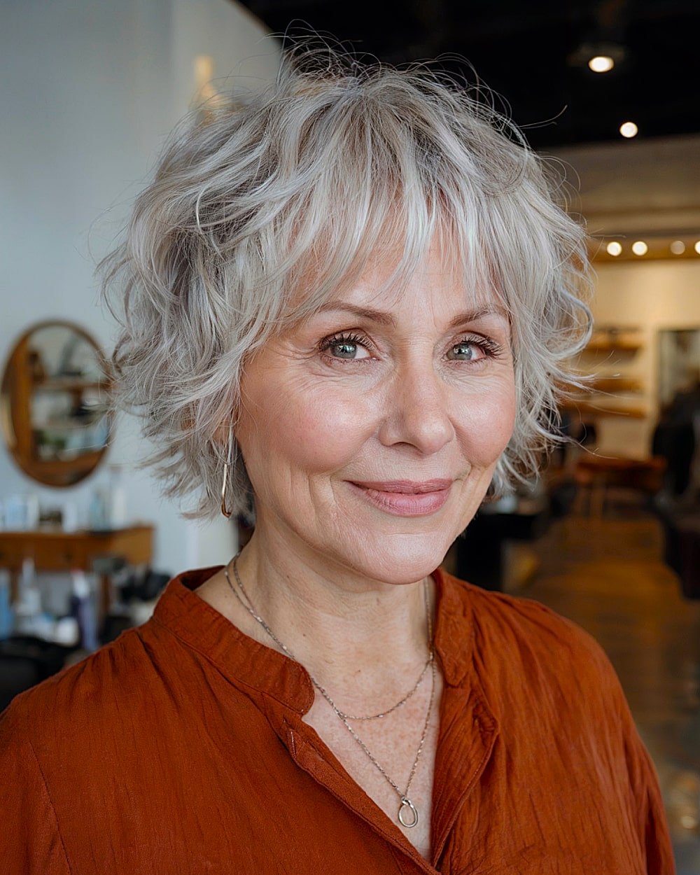 Jaw-length gray haircut with waves and parted layers for women over 60