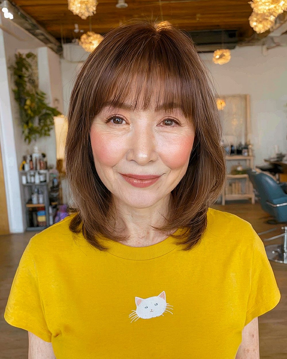 Medium brown layered haircut with soft bangs for women over 60 with fine hair