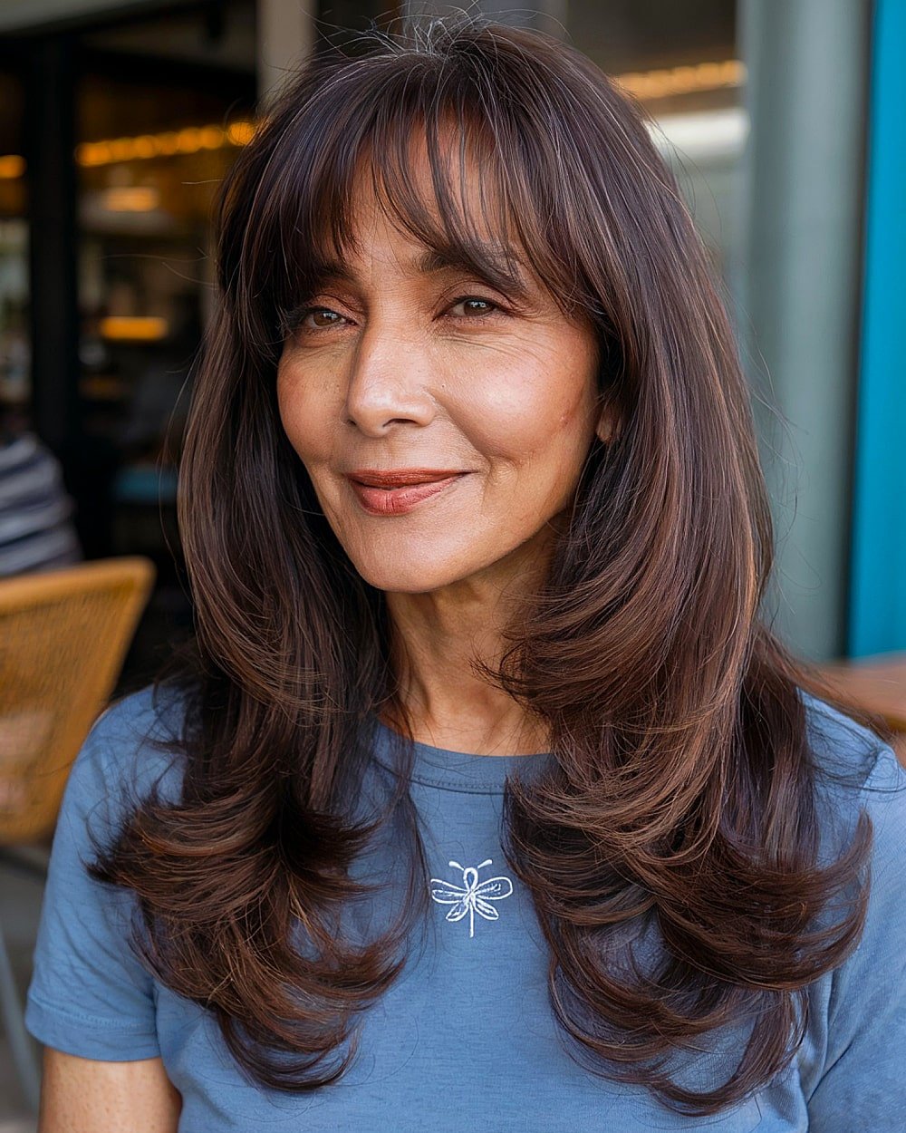 Long layered brunette haircut with curtain bangs for women over 60