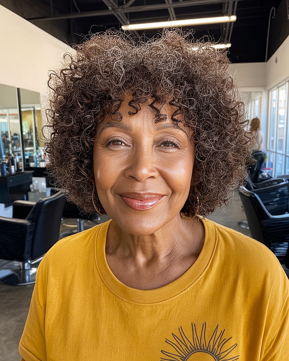 Short layered curly haircut with bangs for women over 60 with naturally curly hair