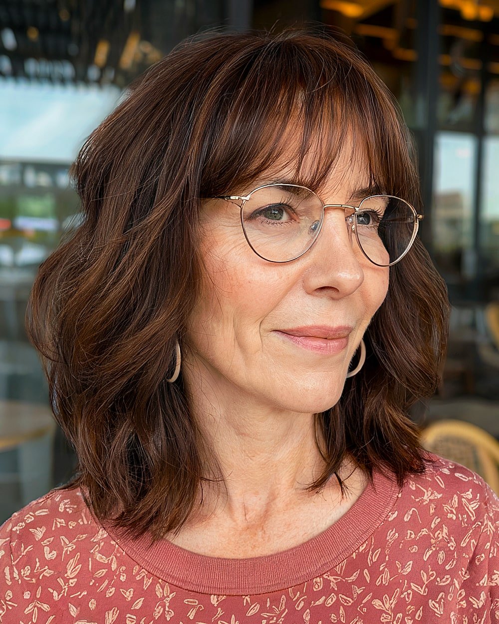 Shoulder length brown hair with soft layers and subtle bangs for women in their 60s