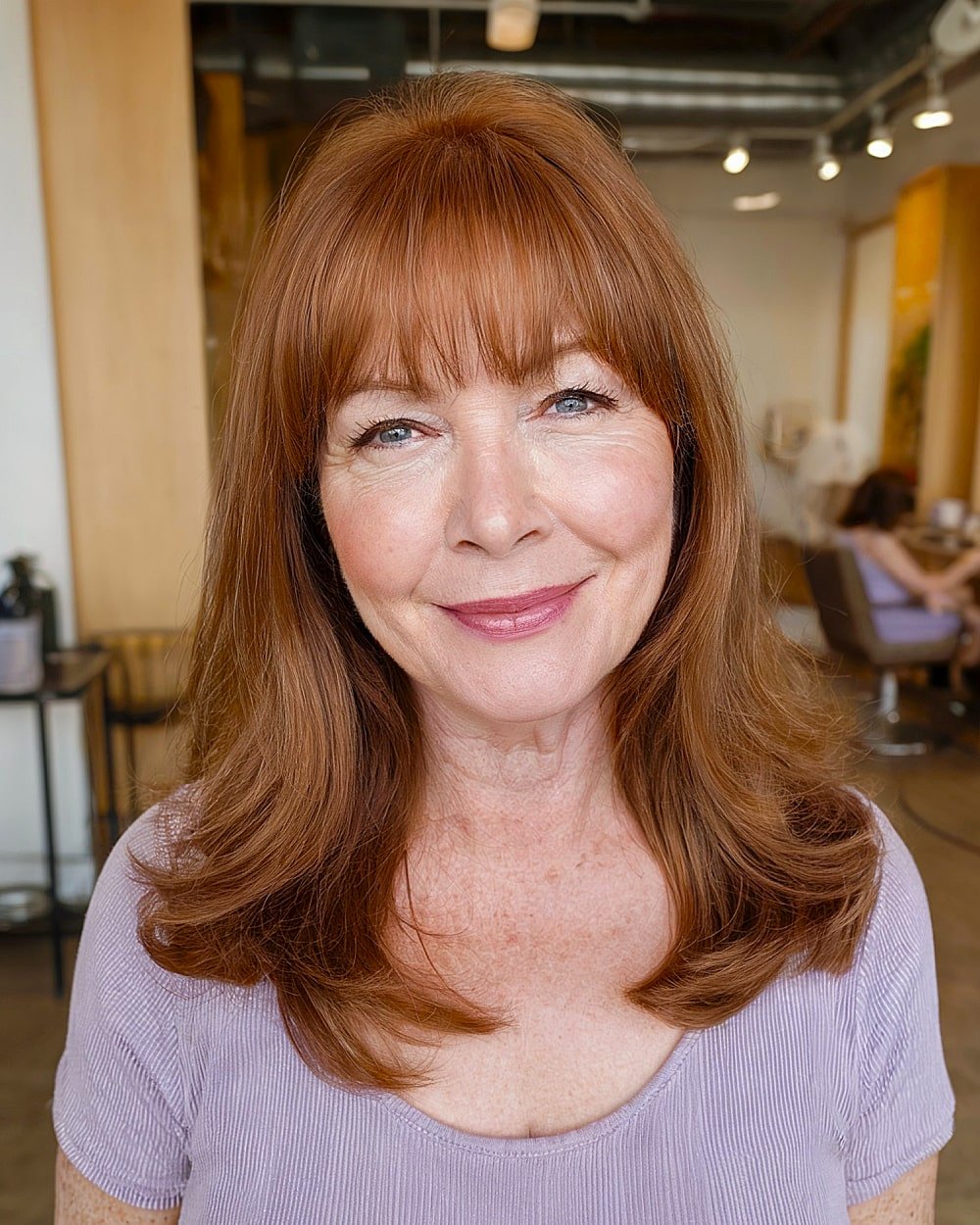 Layered copper hairstyle with full bangs for mature women with thick hair