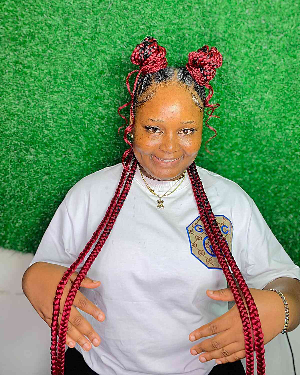 Long vibrant red braids with half up space buns for black woman
