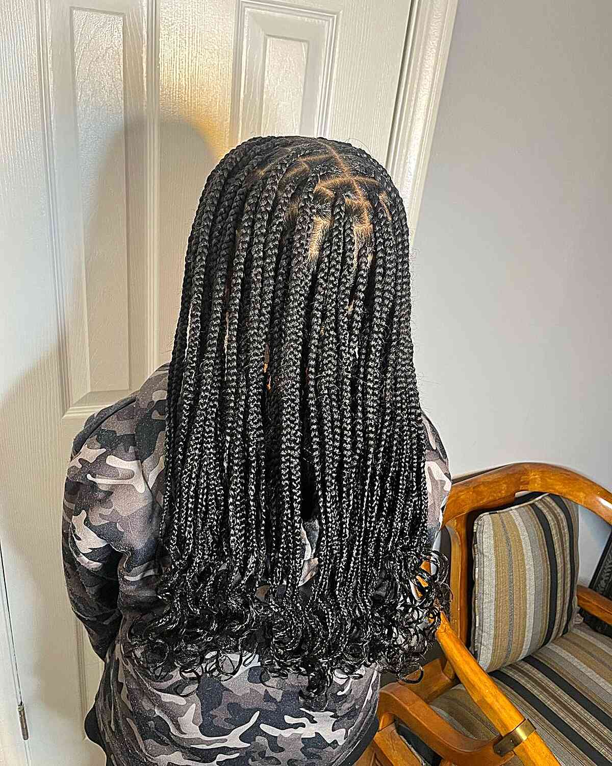 Medium sized knotless protective braids with curly ends on black hair