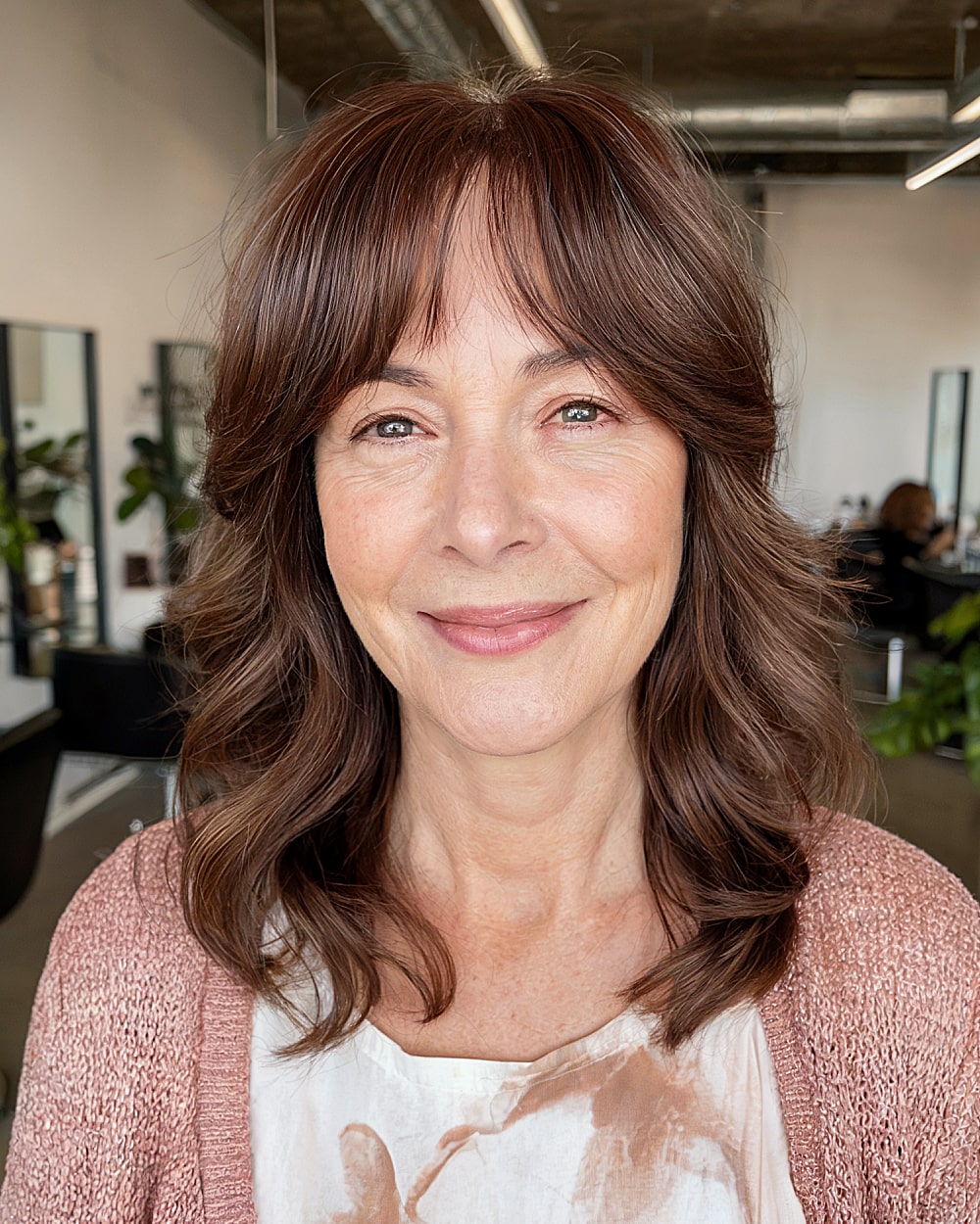 Medium layered haircut with curtain bangs for women over 60 with chestnut hair