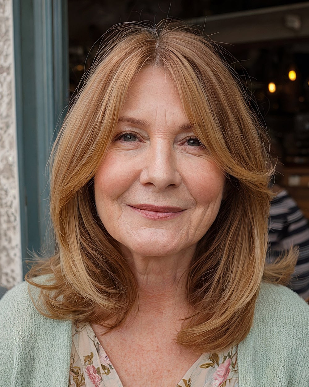 Face-framing layered cut for round faces over 60 with golden blonde hair