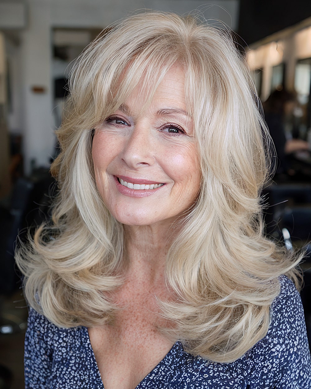 Voluminous medium layers with curtain bangs for women over 60 with blonde hair