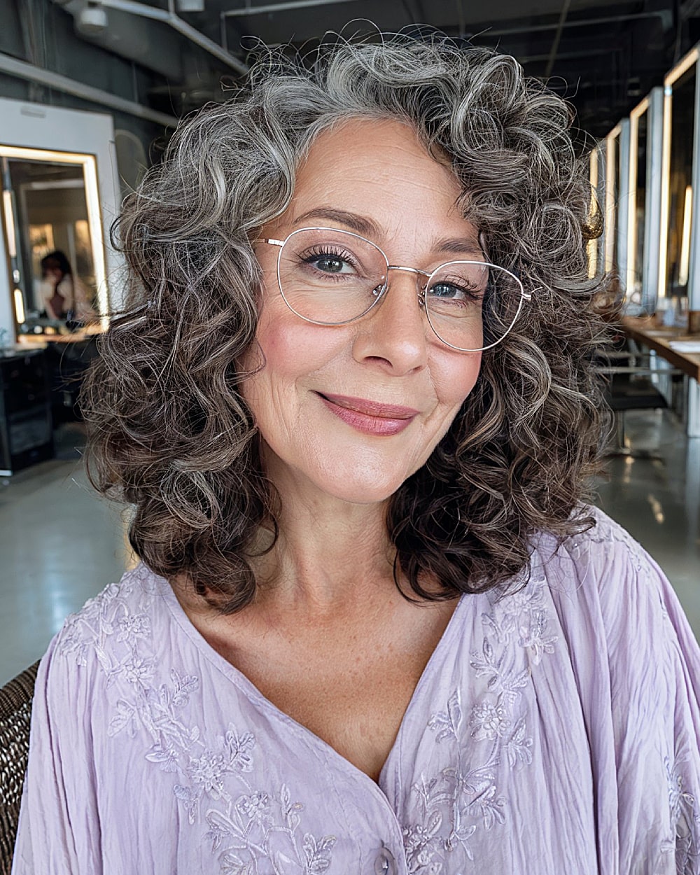 Medium layered haircut for natural curls over 60 with silver and dark tones