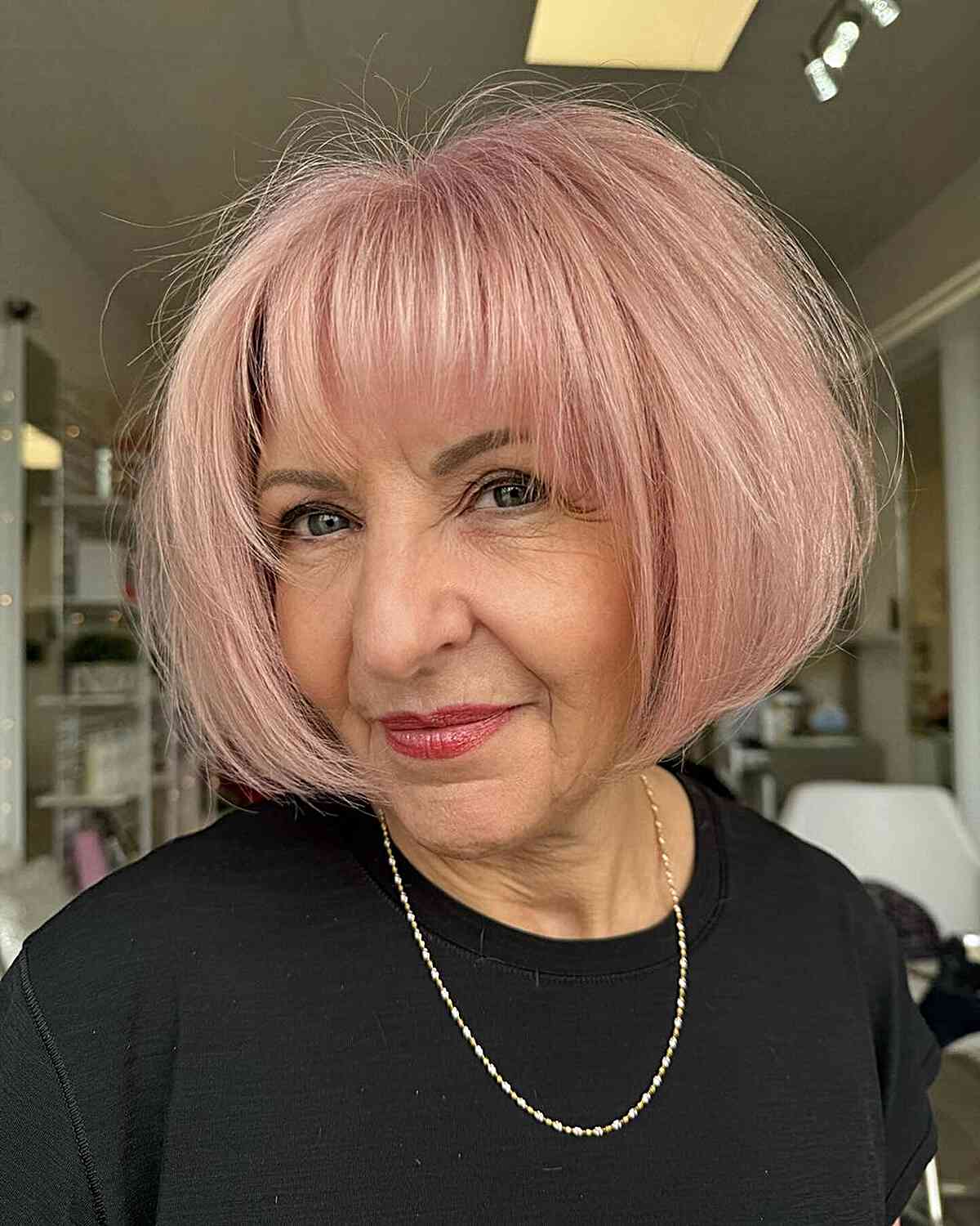 Pink short round thick bob with soft bangs for women aged 60 and above