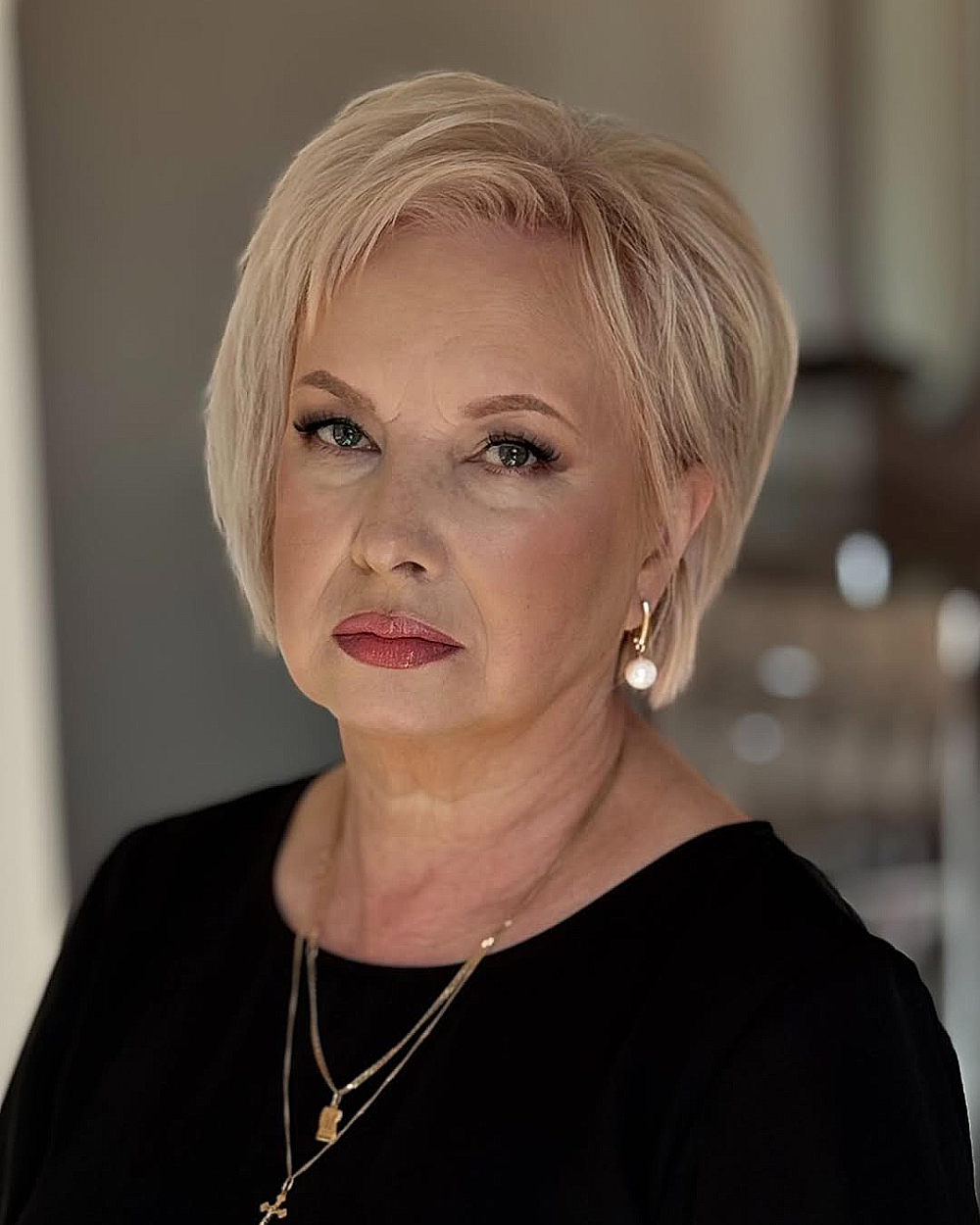 Short layered pixie bob with side bangs for women over 60, soft blonde tone, light texture and volume