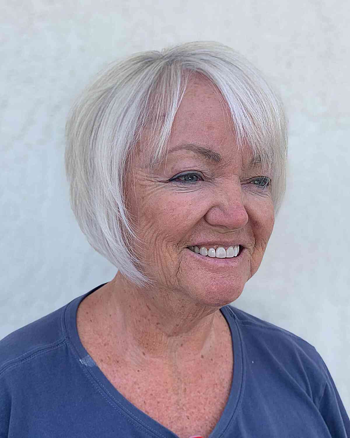 Platinum white bob with side bangs for women over 60 with thin hair and round face shapes