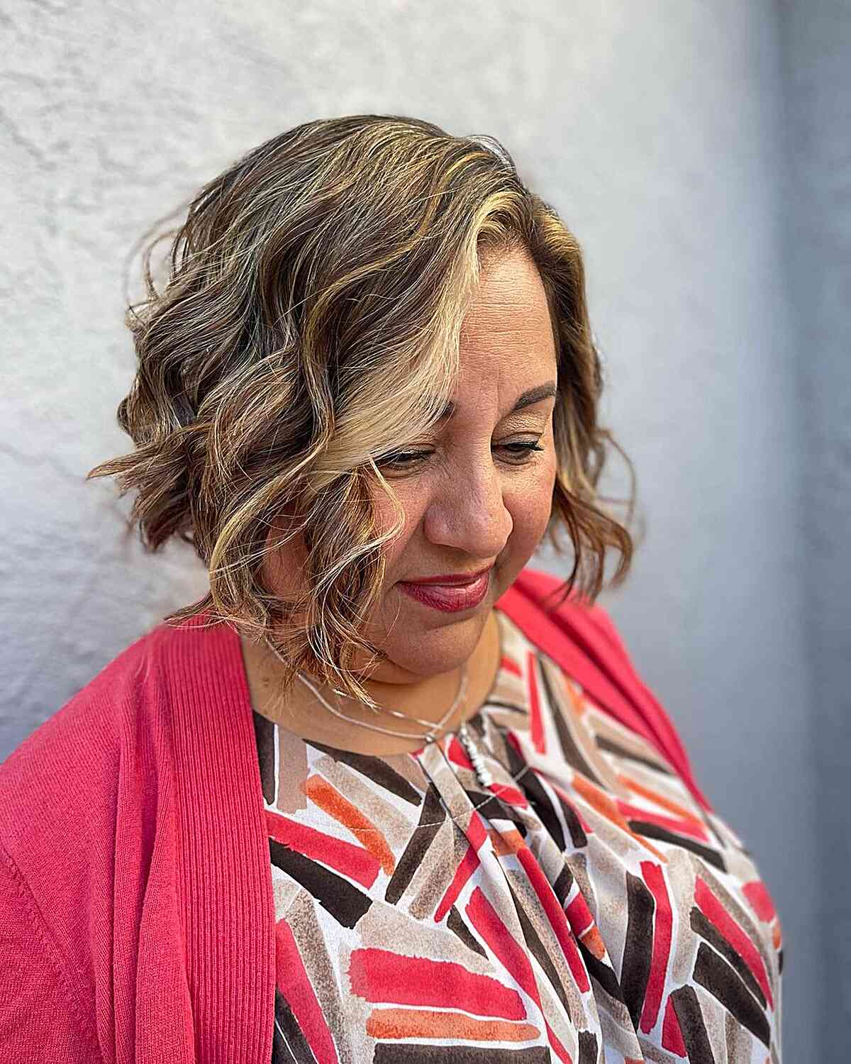 Chin-length wavy bob style for women over 60 with round shaped faces