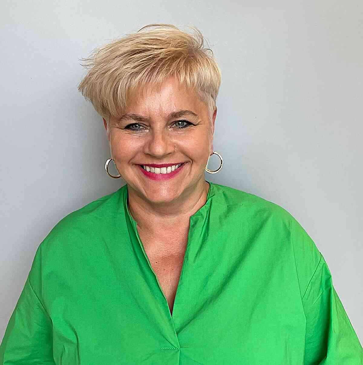 Short pixie with asymmetric bangs for older women over 60 with round faces