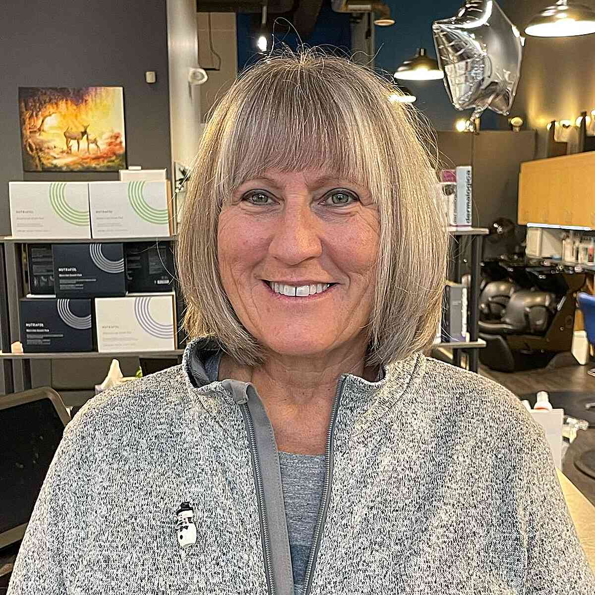 Short gray hair with full bangs on round face for 60 year old women