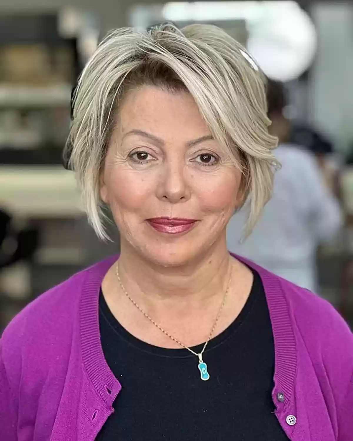 Chin-length layered bob with long bangs for women over 60 with round faces