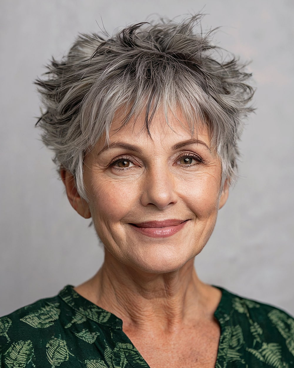 Tousled pixie shag for women over 60 with gray hair and dark root shadow