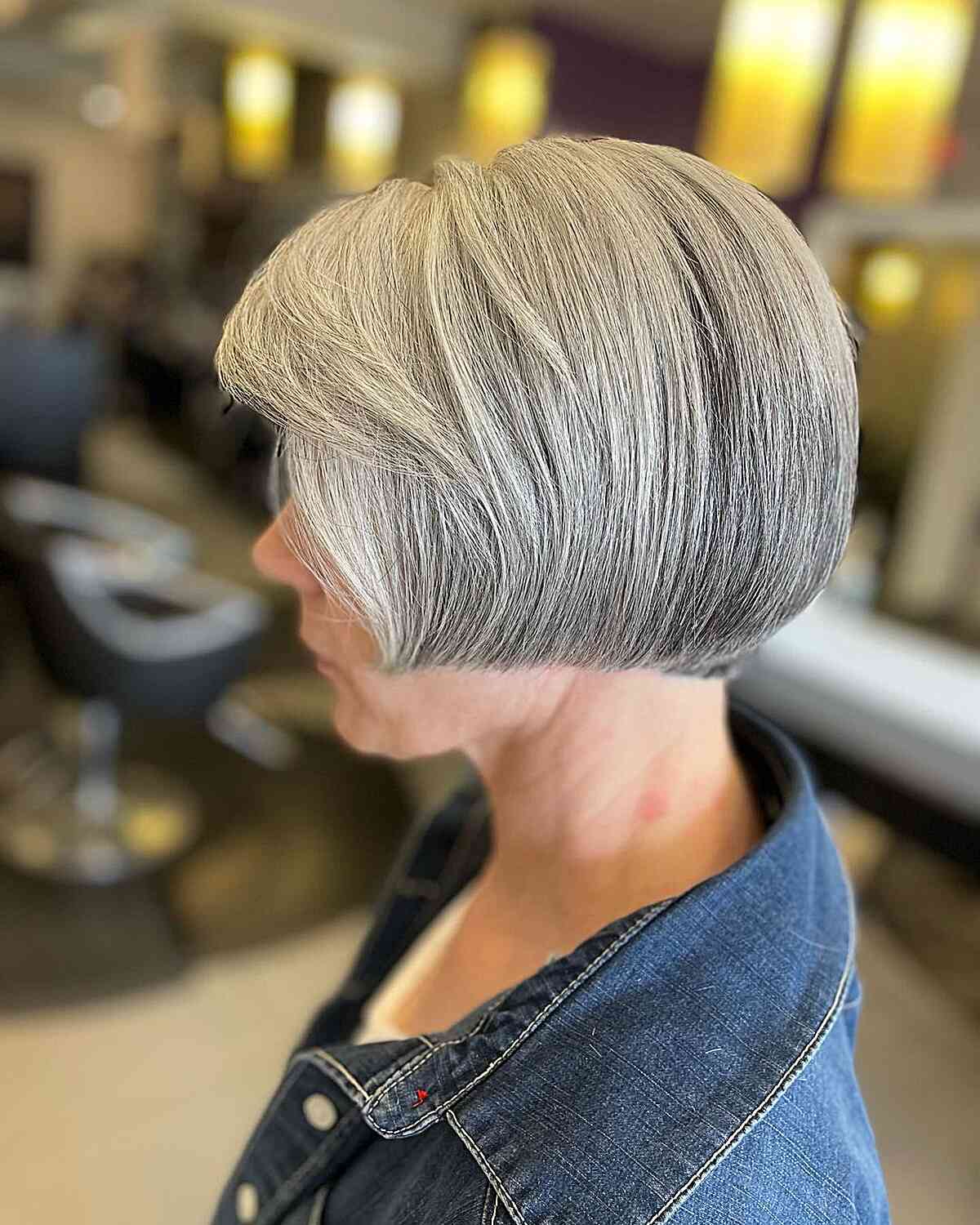 A short jaw-length bob with straight edges and side bangs for older women over sixty
