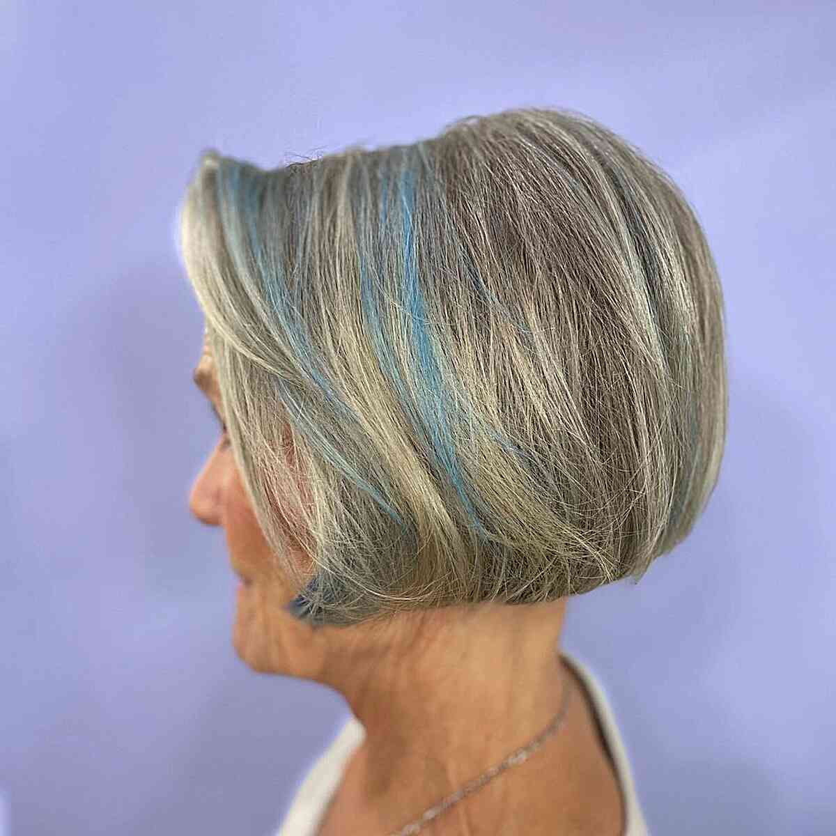 A short salt and pepper bob with blue accents for the modern 60+ woman