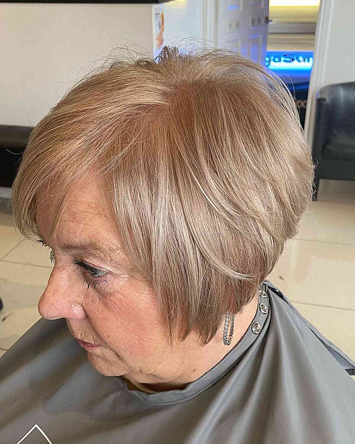 Short, jaw-length layered bob with beige blonde color for 60 year olds