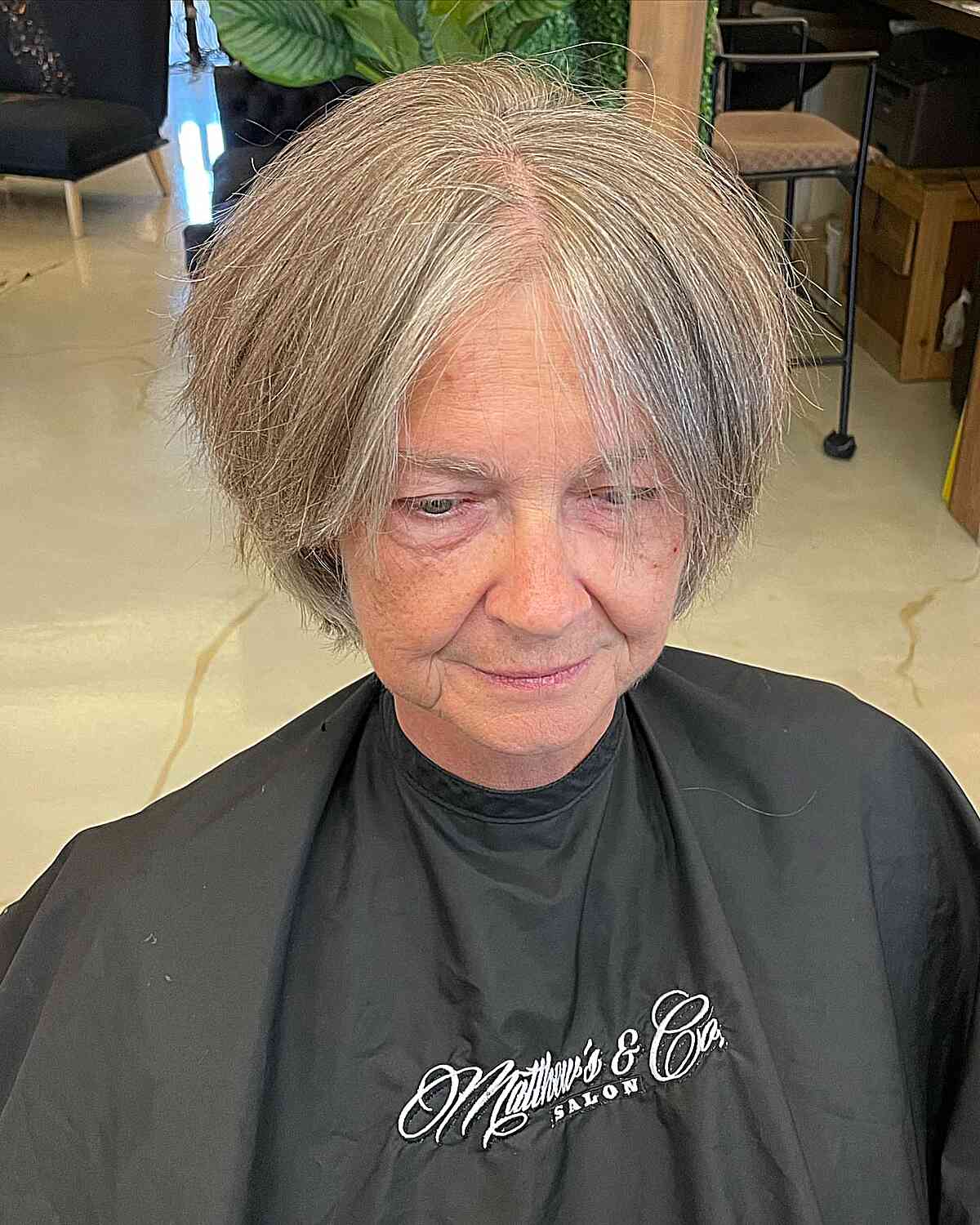Jaw length gray pixie with long side bangs for 60 year old women