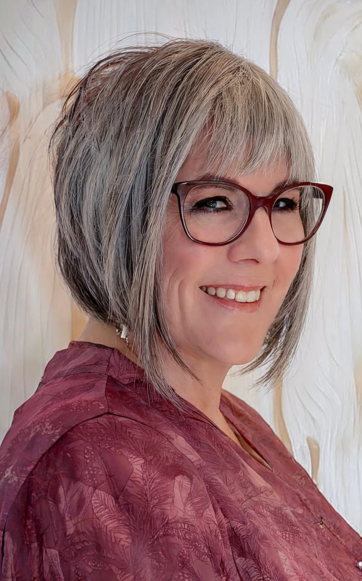 Short angled gray bob with asymmetrical bangs for 60 year old ladies