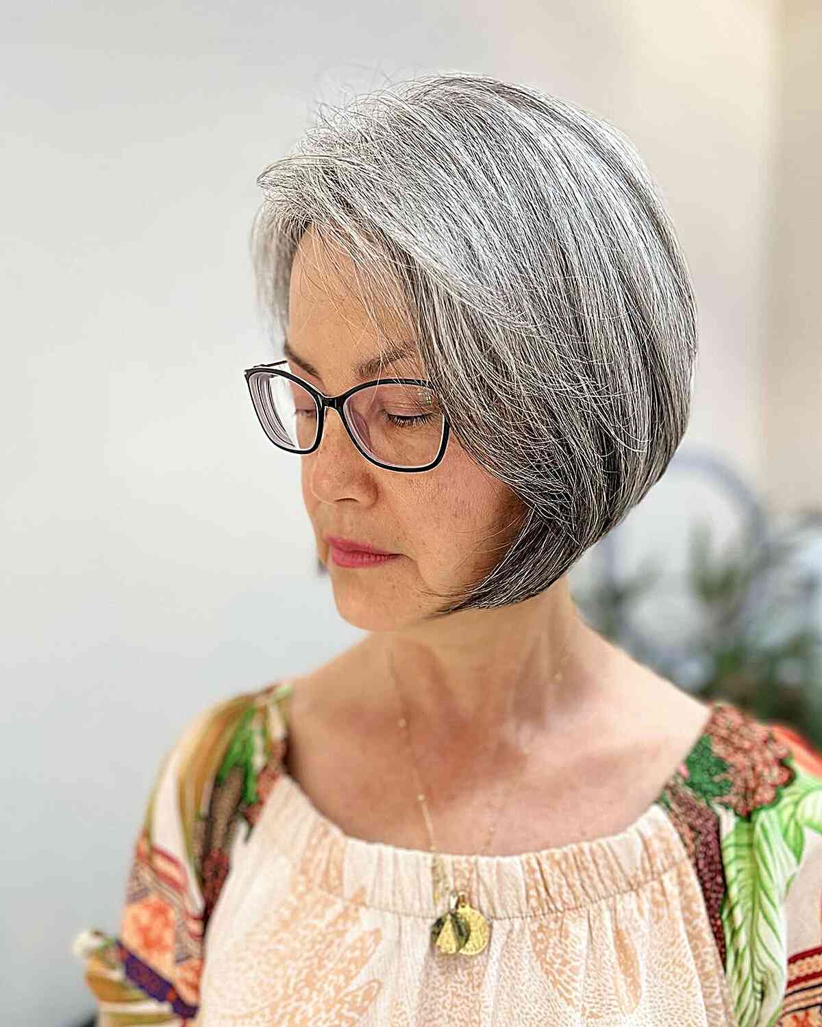 Gray chin length bob with side part for 60 year old women with thick locks
