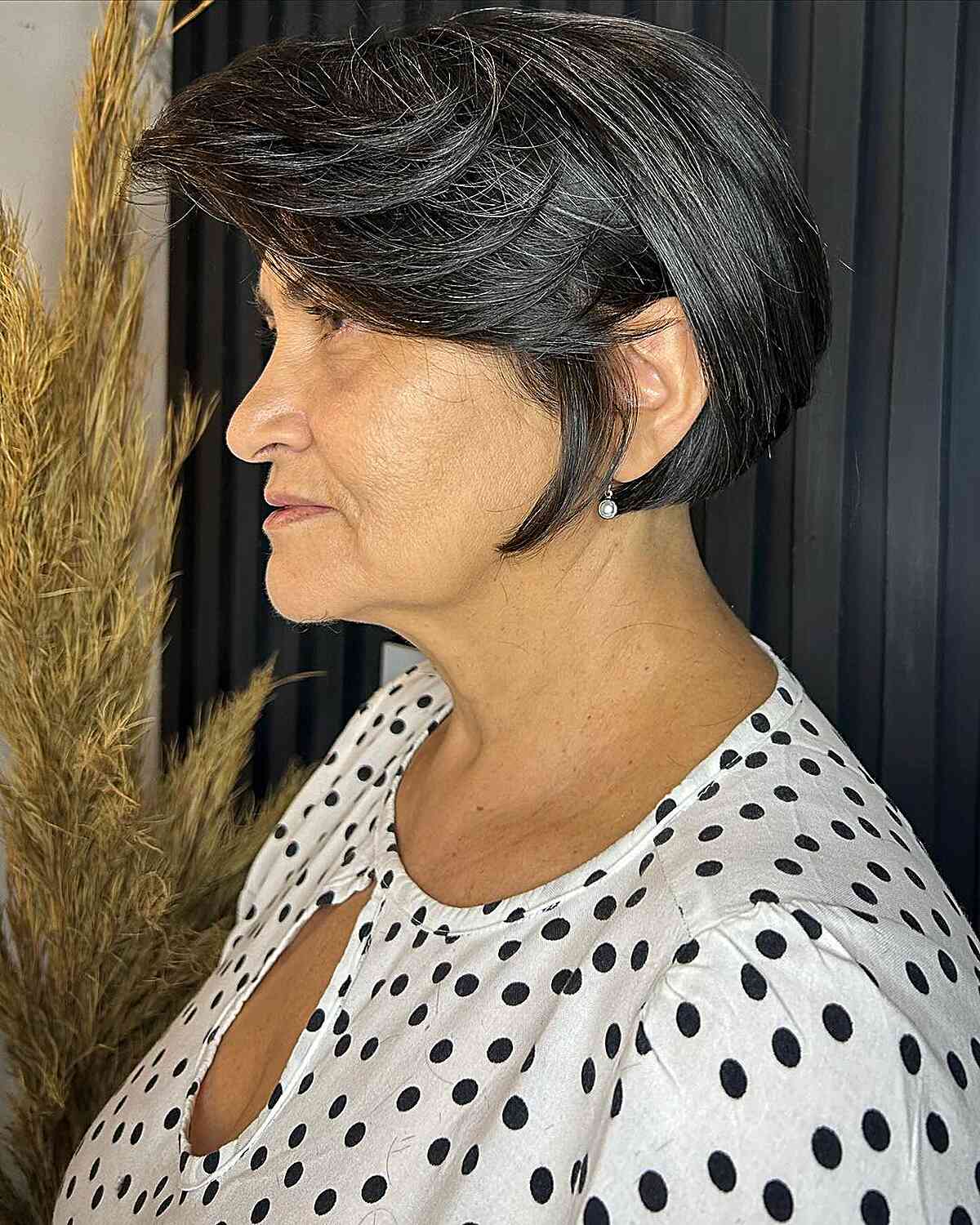 Short voluminous wedge bob with layered bangs for thick hair over 60 years old