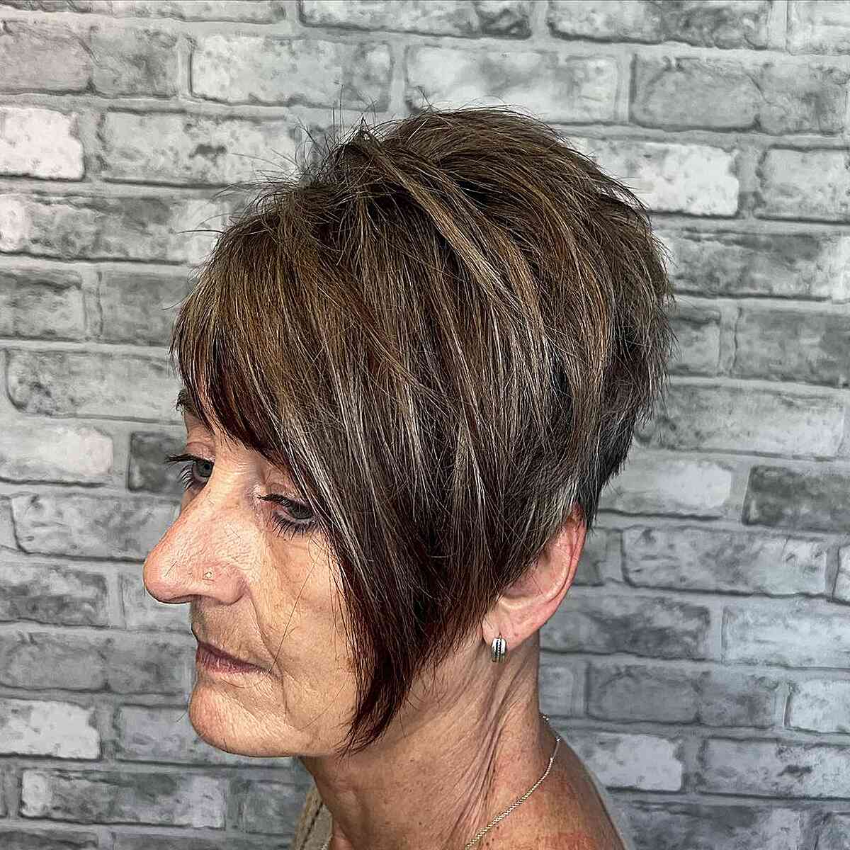 A long edgy pixie with a tapered butt for women over 60 and older with thick hair