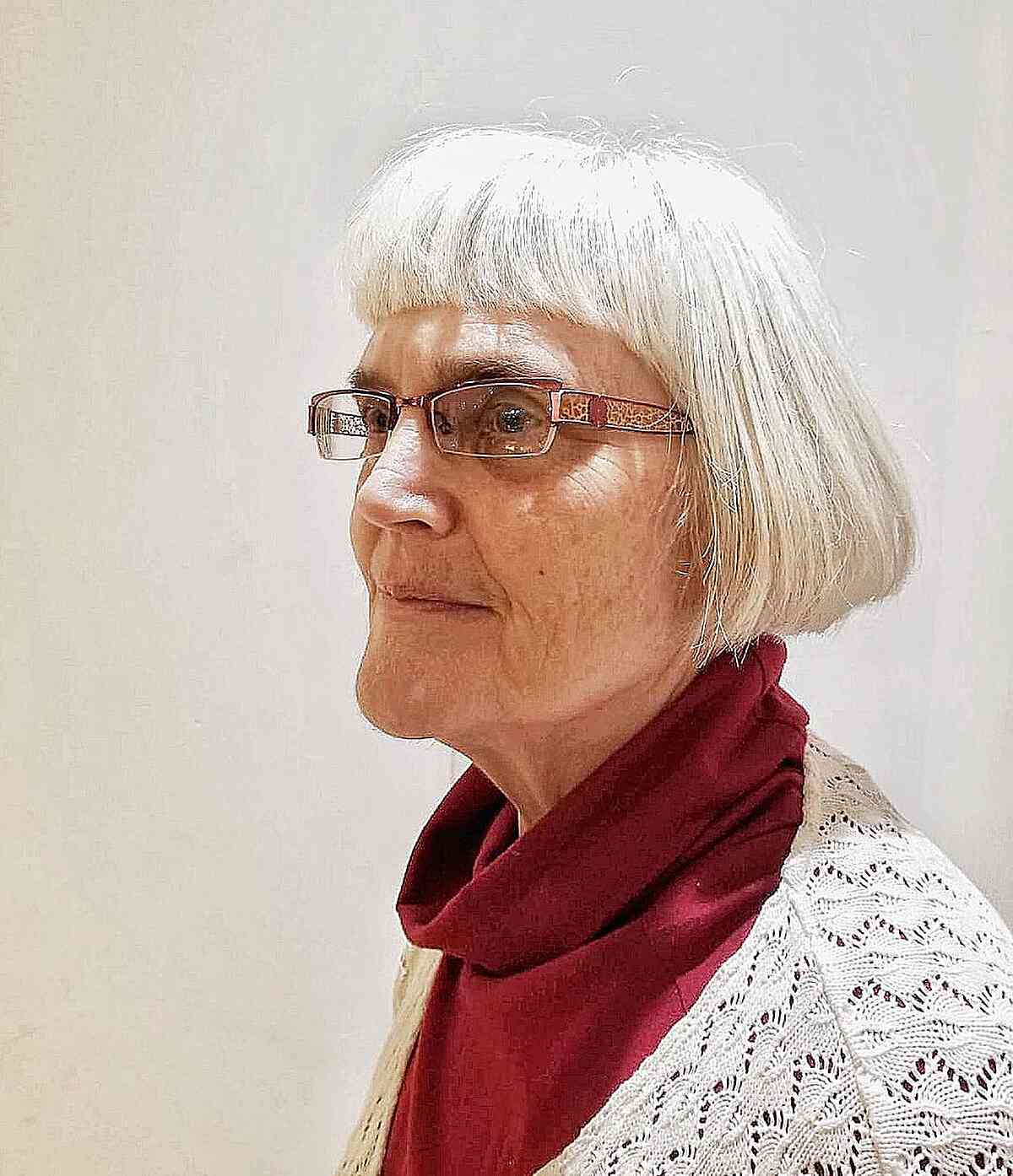 One length thick short cut with blunt bangs for women in their 60s with glasses
